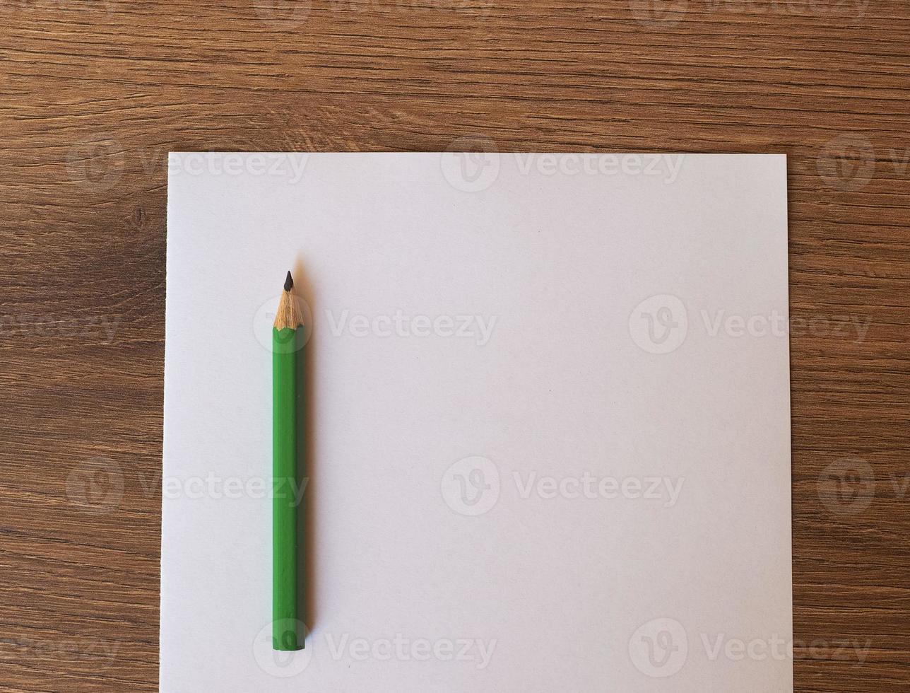 green pencil on paper sheet desk photo