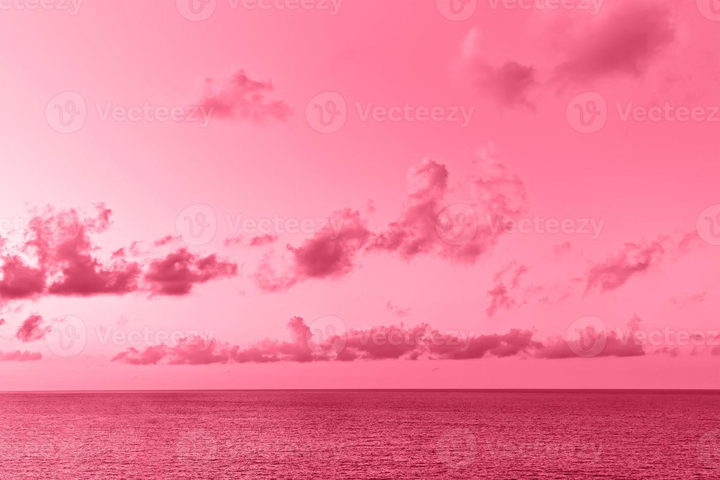 Lovely seascape with cumulus clouds above sea surface. Image toned in color of the year 2023 viva magenta. photo