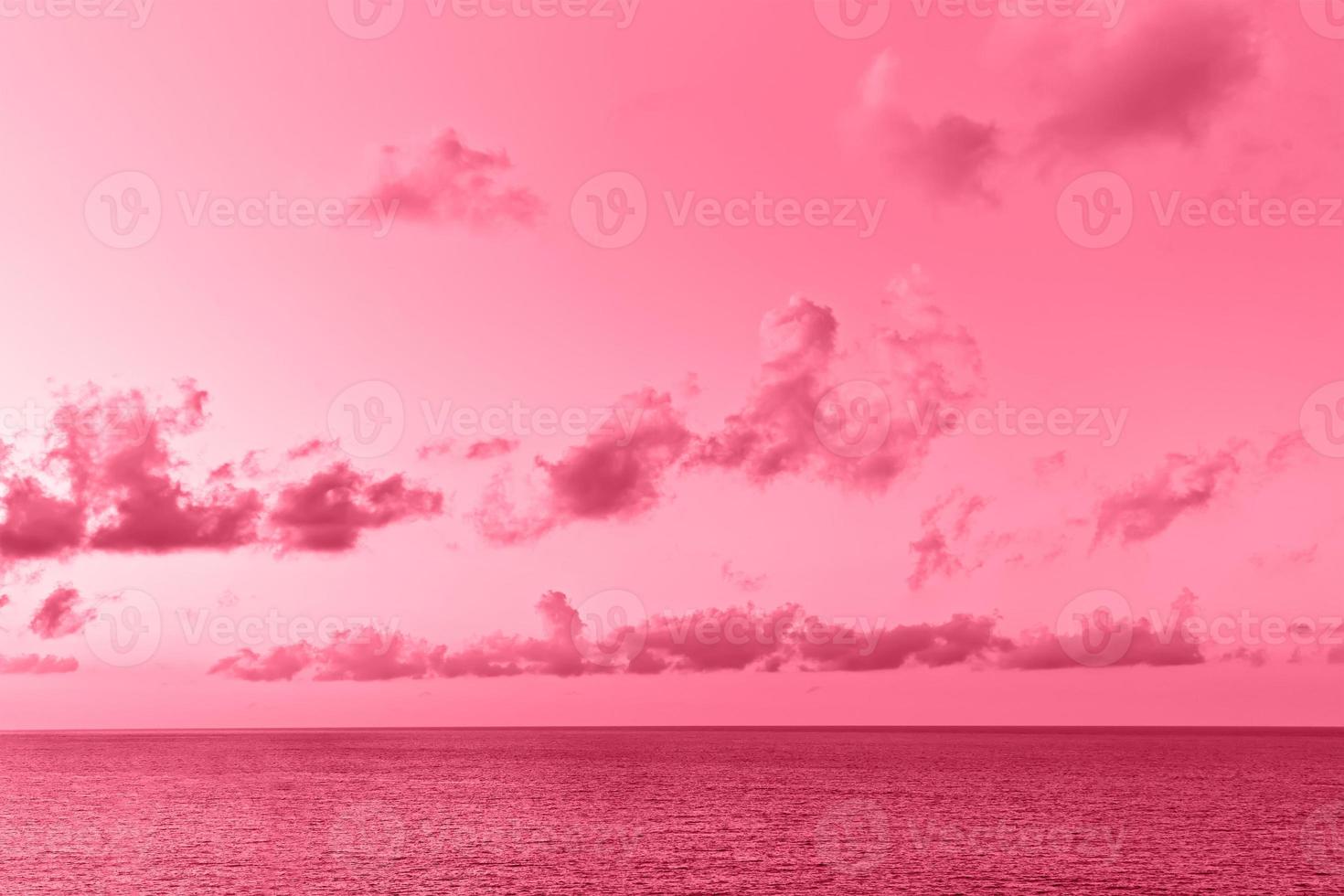 precioso paisaje marino con cúmulos sobre la superficie del mar. imagen tonificada en color del año 2023 viva magenta. foto