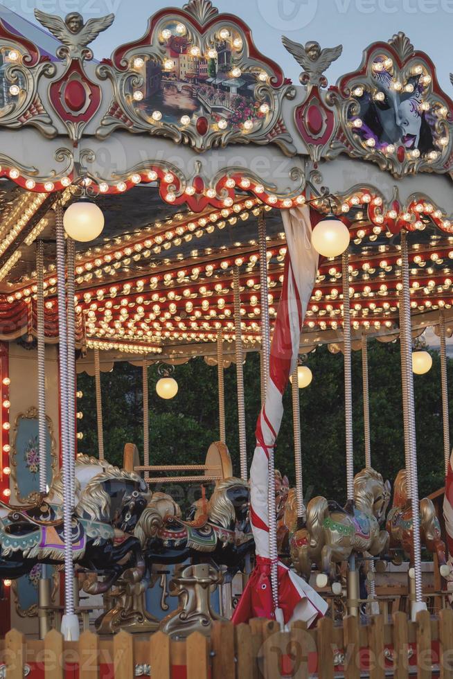 Empty vintage carousel horses during traditional Christmas fairy market, closeup. photo