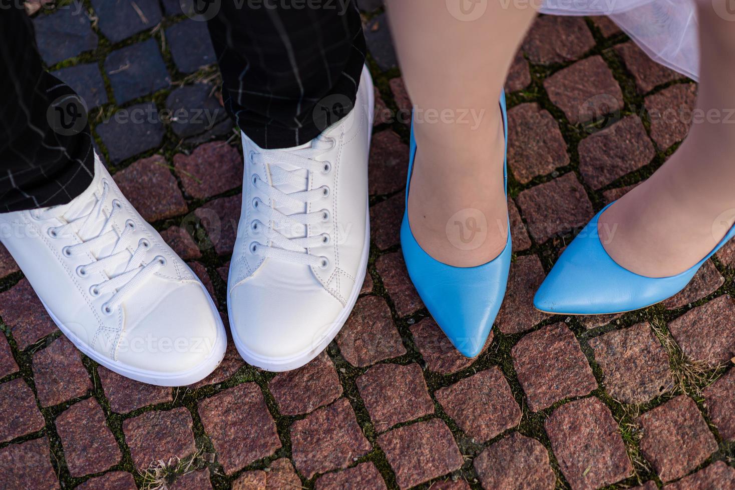 foots of bride and groom . The bride and groom holding on hands and walking on road in the nature. Outdoors. Down view at shoes. photo