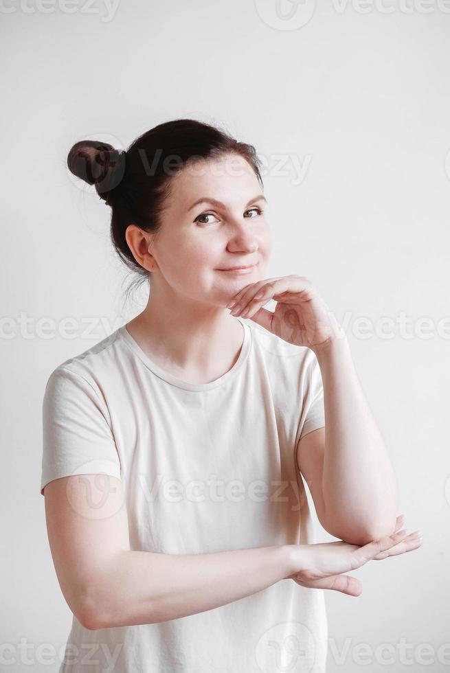 Beautiful woman with pigtails and a funny face wearing a T-shirt on a white background. Copy, empty space photo