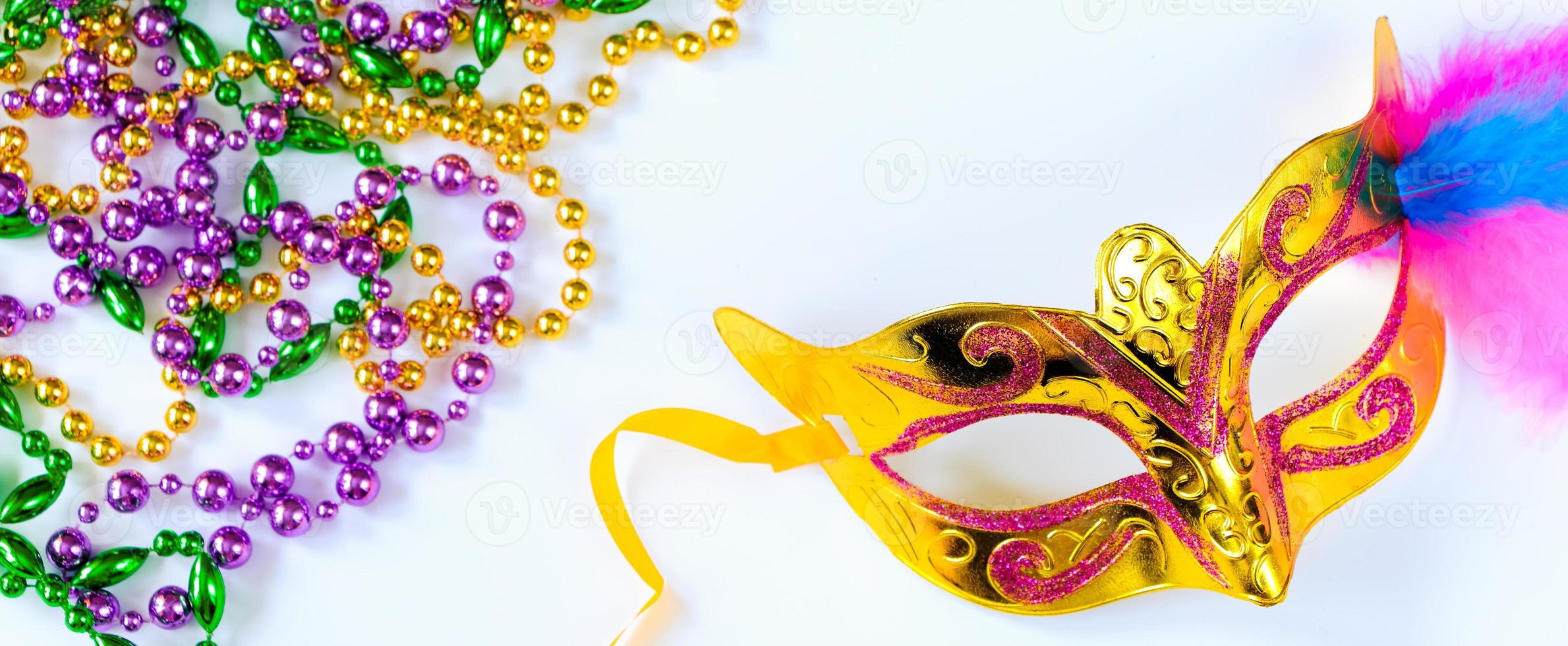 Carnival mask with feathers and colorful beads on white background. Mardi Gras or Fat Tuesday symbol. photo