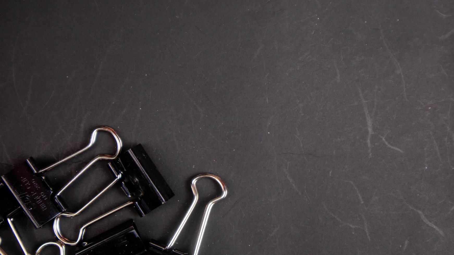 a black paper clip on a black background photo