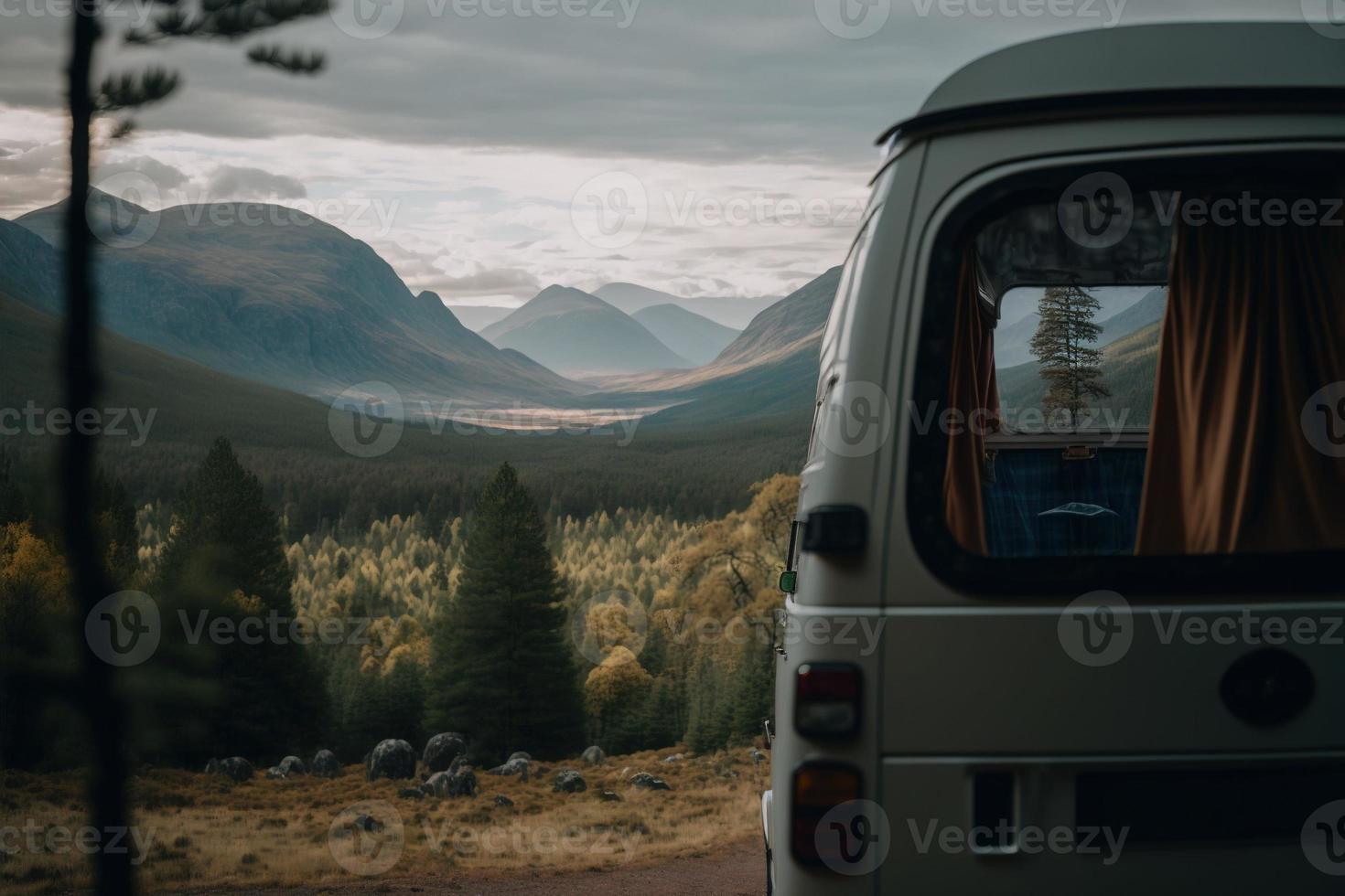 A retro campervan is parked in a beautiful, secluded spot in the great outdoors. It has a small awning and the windows are open, inviting adventurers to explore. The essence of van life. photo