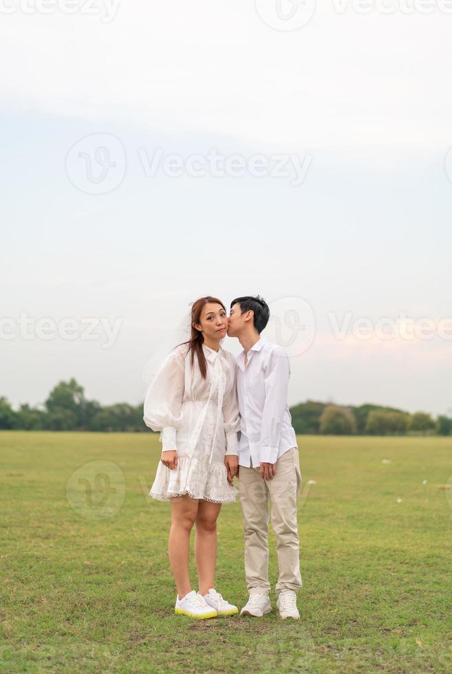 feliz joven pareja asiática vestida de novia y novio foto