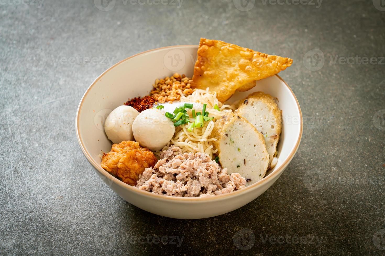 spicy egg noodles with fish balls and shrimp balls without soup photo