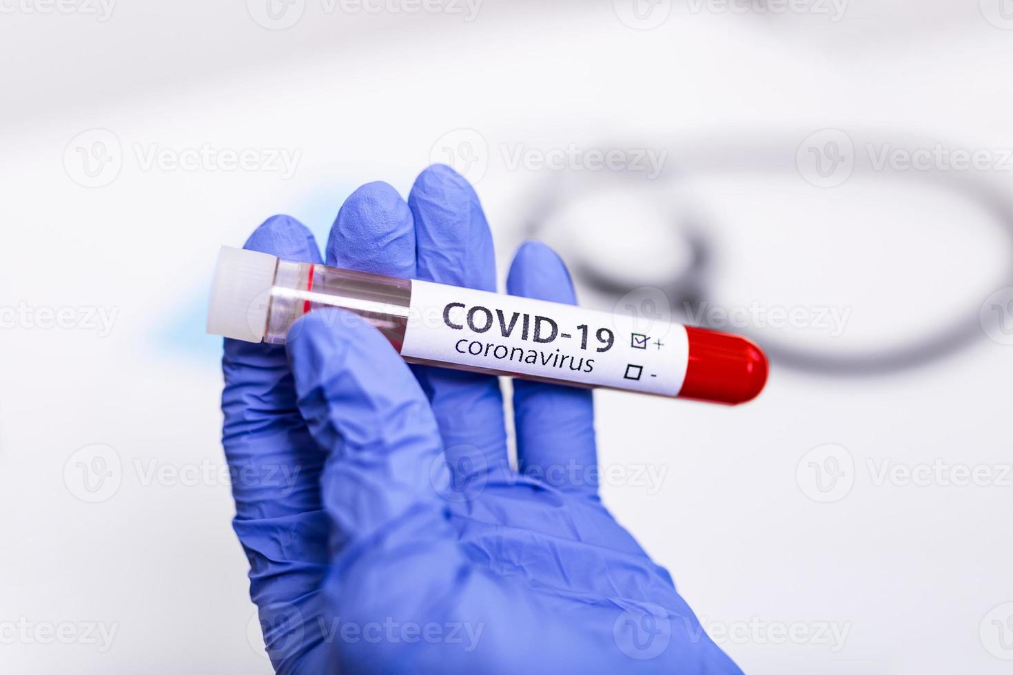 Coronavirus covid-19 infected blood sample in sample tube in hand of coronavirus scientist with biohazard protection cloth , coronavirus covid-19 vaccine research photo