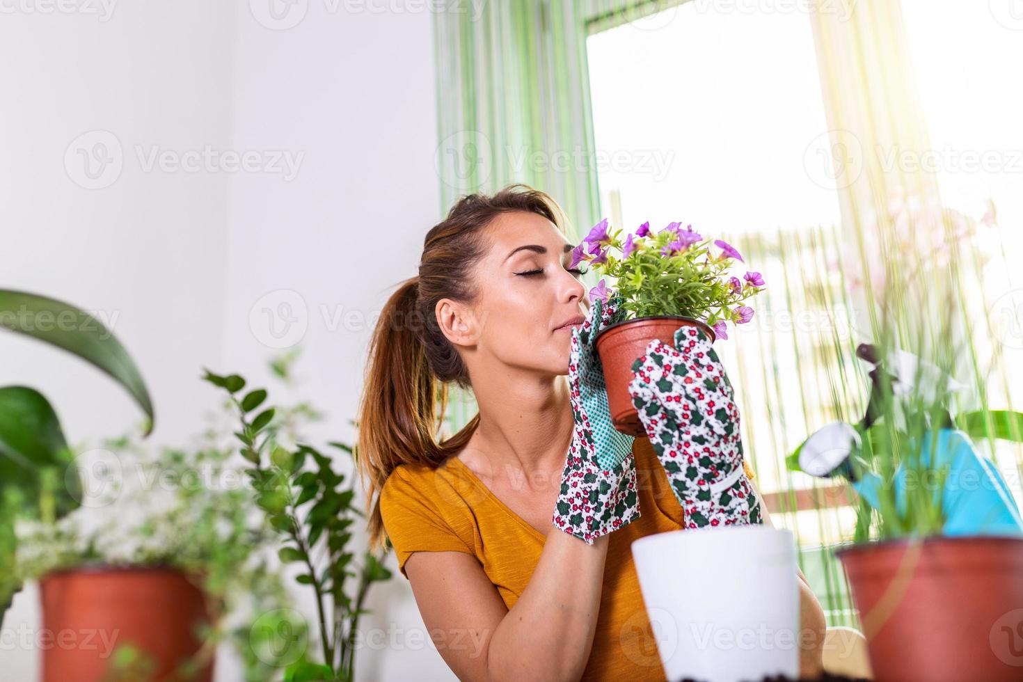 Lovely housewife with flower in pot and gardening set. Work at home. Planting a flower and spring cleaning. The housewife changes ground for a plant. Care for a potted plant photo