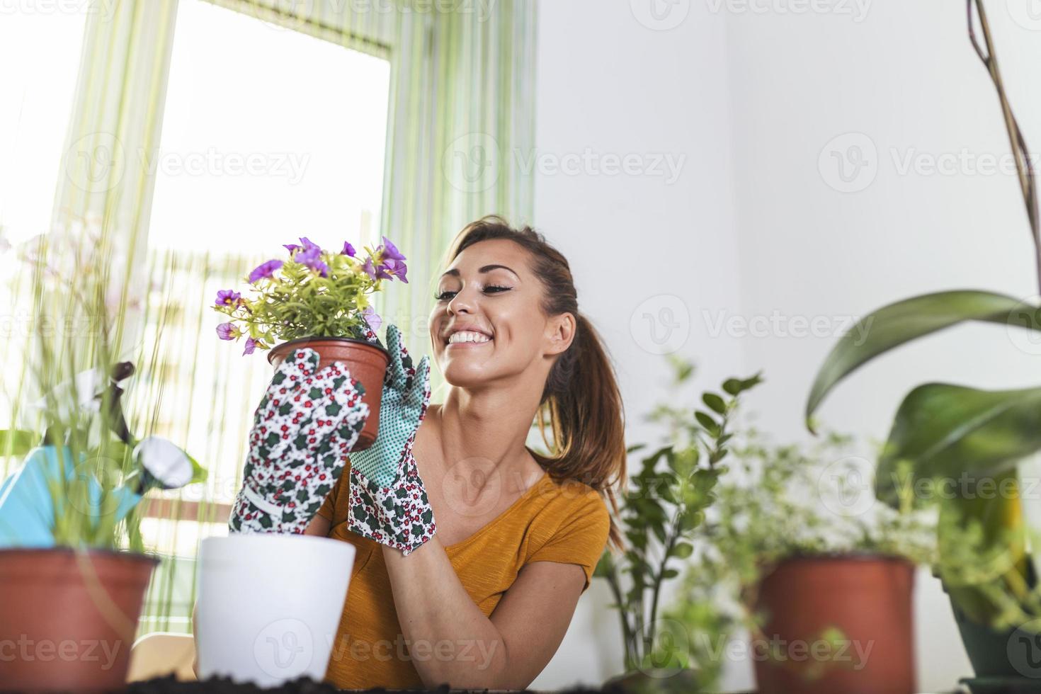 mujer preparando flores para plantar. jardinero plantando flores en maceta. mujer joven preparando flores para plantar durante el trabajo de jardinería. personas, jardinería, plantación de flores y concepto de profesión. foto