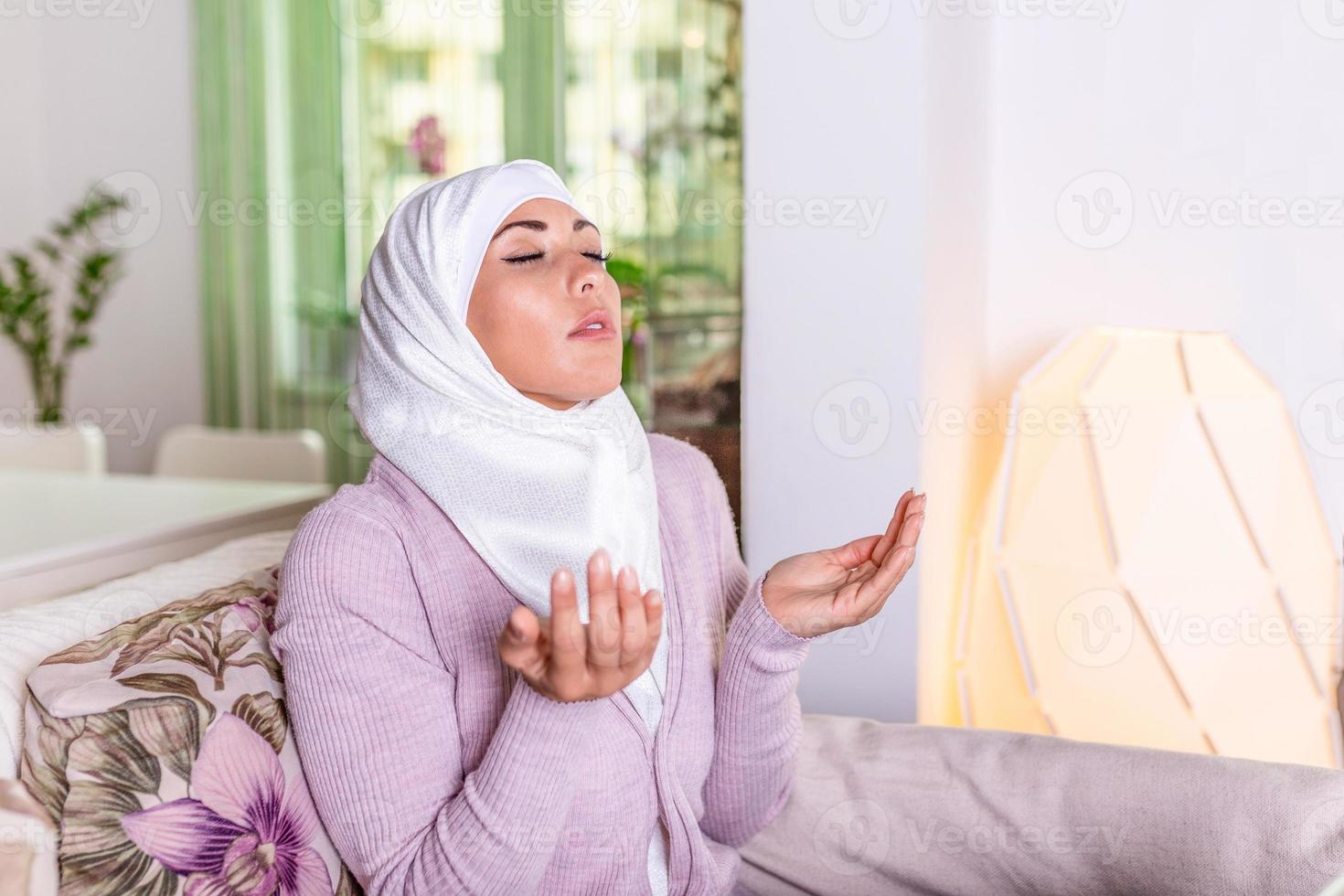 Young Woman Praying. Young Muslim woman praying, indoors. Young muslim woman in beige hijab and traditional clothes praying for Allah, copy space. Arab Muslim woman praying photo
