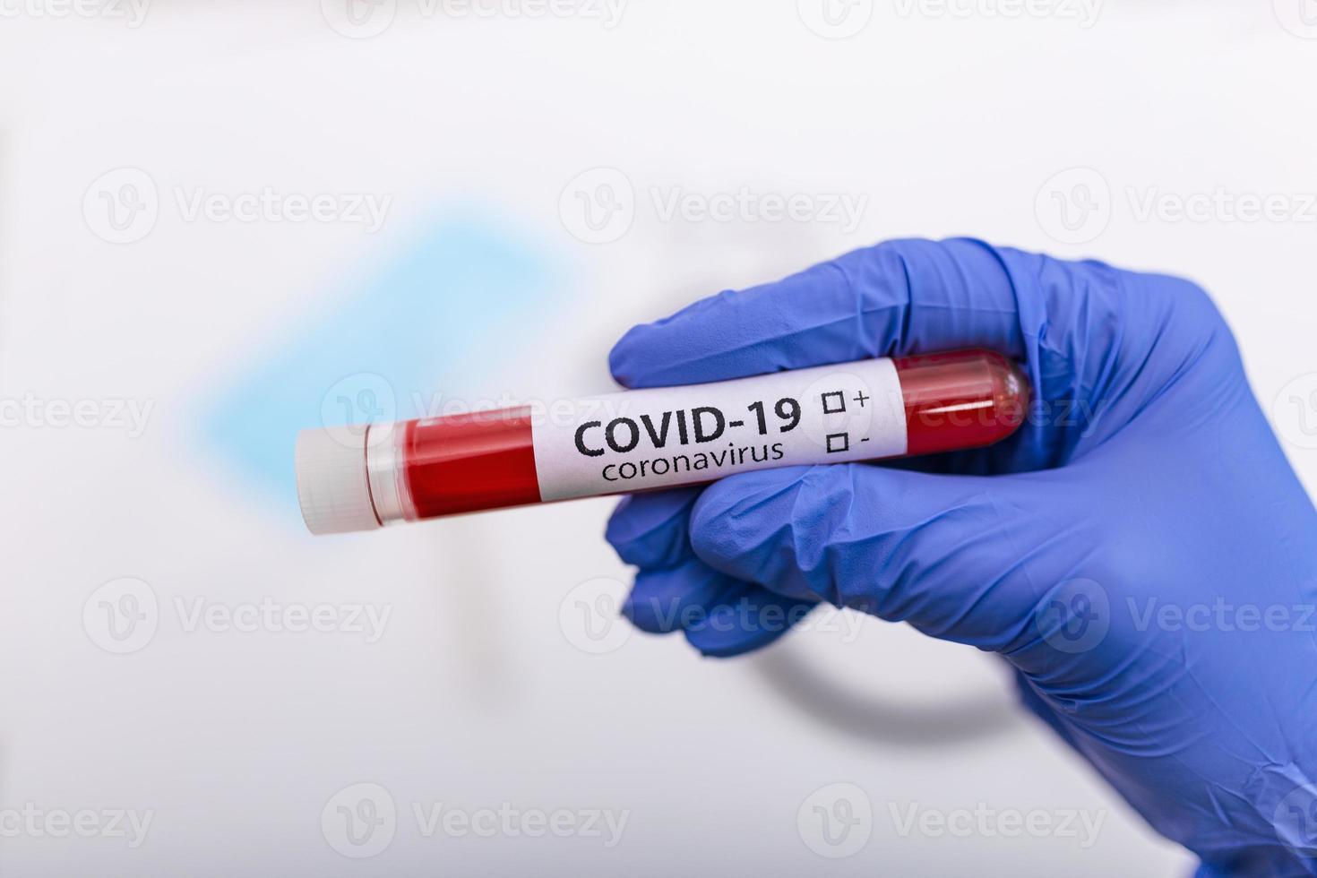 Coronavirus Covid 19 infected blood sample in sample tube in hand of scientist doctor biohazard protection clothing in coronavirus covid 19 research laboratory, Coronavirus Covid-19 vaccine research photo