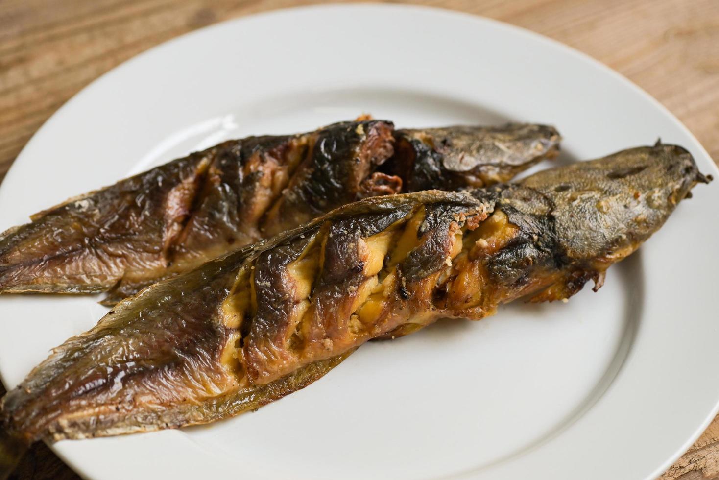 bagre a la parrilla en un plato blanco, comida tailandesa cocinando bagre pescado de agua dulce foto