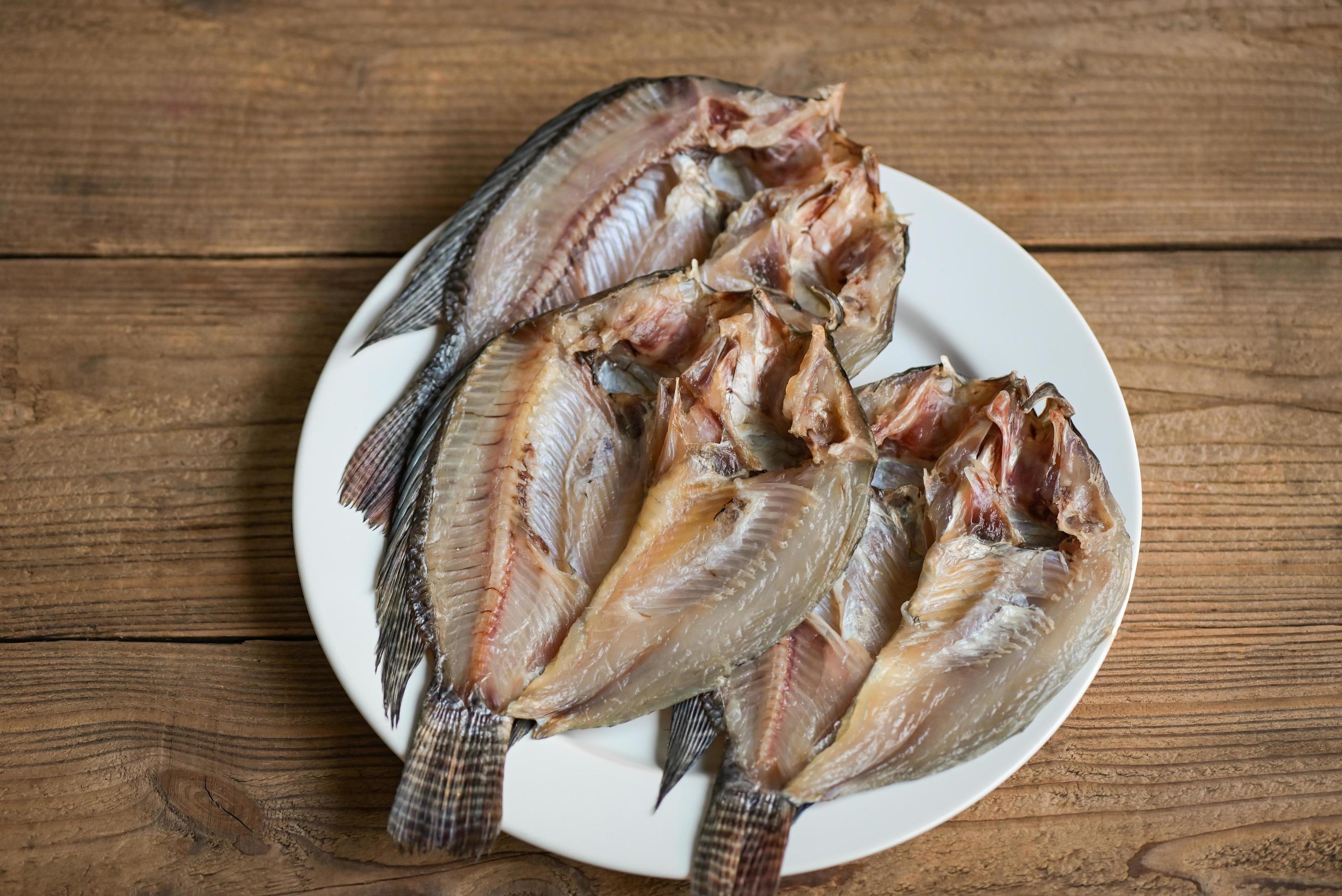 pescado seco en plato blanco, pescado tilapia para cocinar alimentos en
