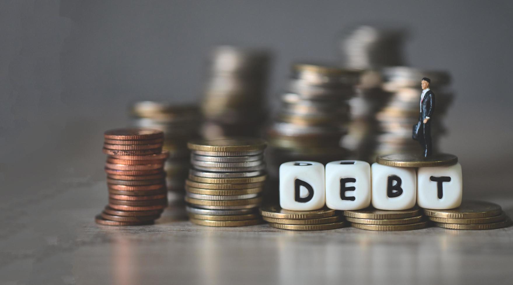 Debt business economy of money and finance word debt on coins with business man, Payment of taxes and of debt to the state, concept of financial photo