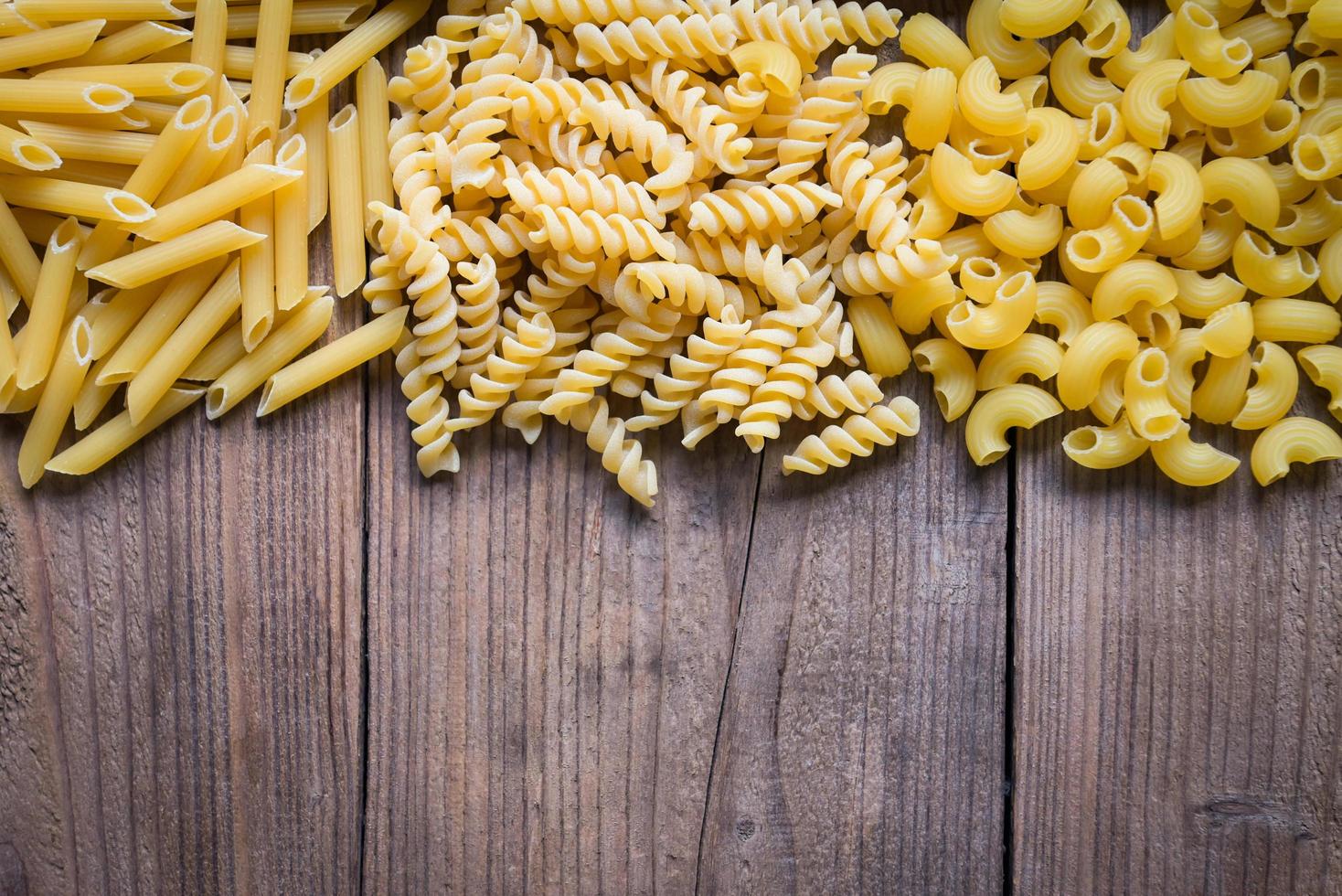 fondo de pasta, fondo de textura de macarrones crudos, pasta penne y pasta espiral deliciosa pasta sin cocer para cocinar alimentos foto