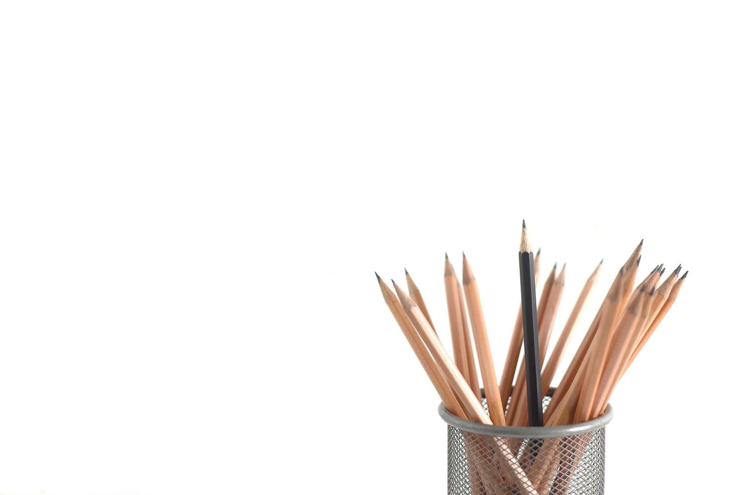 Individuality concept - black pencil surrounded by wooden brown pencils photo