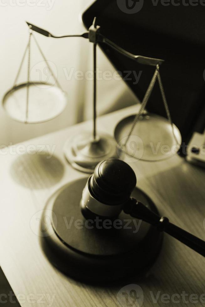 Justice and law concept.Male judge in a courtroom with the gavel, working with, computer and docking keyboard, eyeglasses, on table in morning light photo