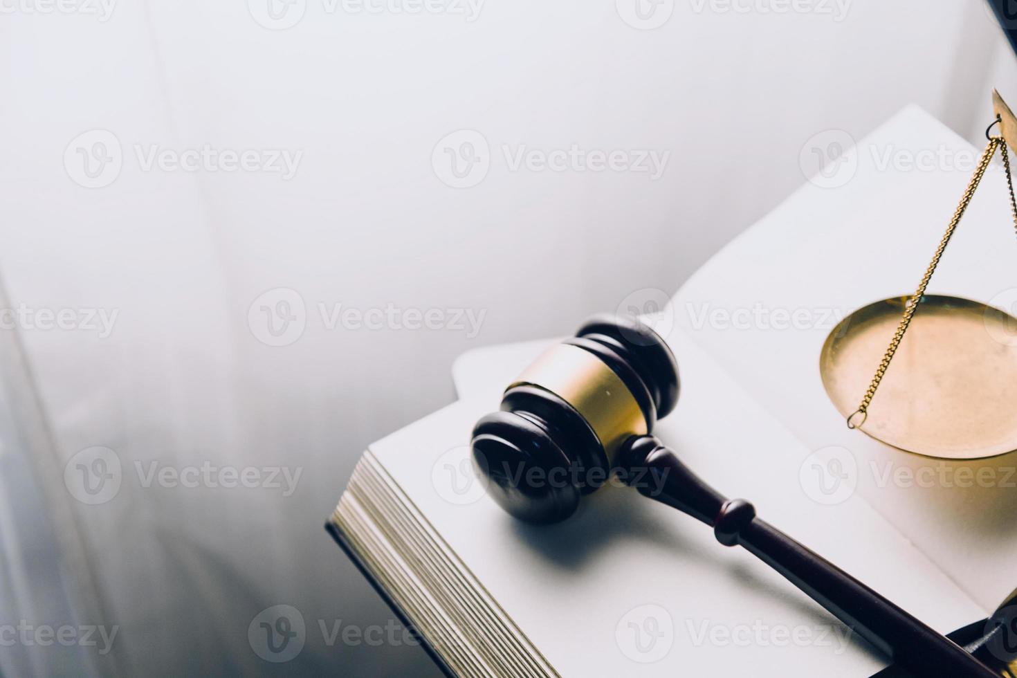 Justice and law concept.Male judge in a courtroom with the gavel, working with, computer and docking keyboard, eyeglasses, on table in morning light photo