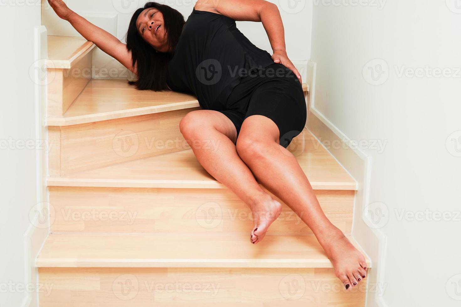 Asian lady woman injury from falling down on slippery surfaces stairs at home. photo