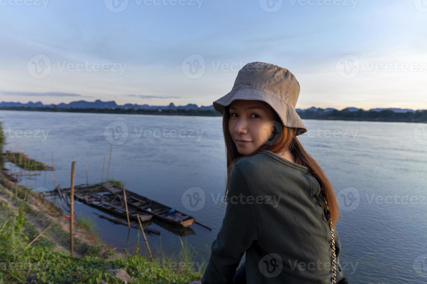 Asian woman in hat looking at camera with Mekong river view in the background photo