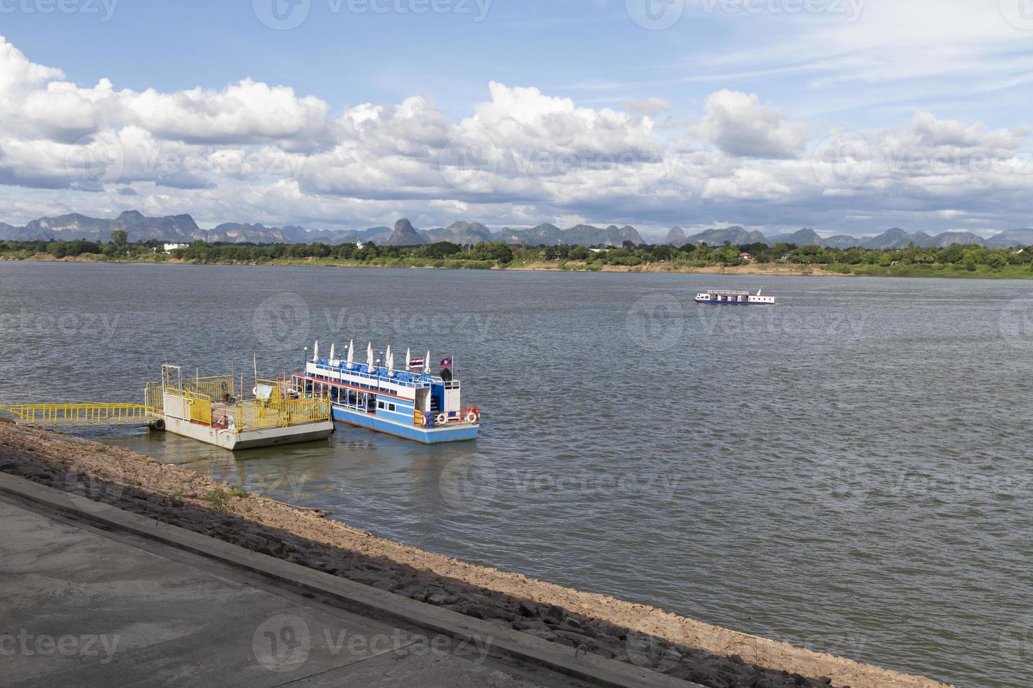 Passenger boats cross the Mekong River between Thailand and Laos at Nakhon Phanom Province, Thailand. photo