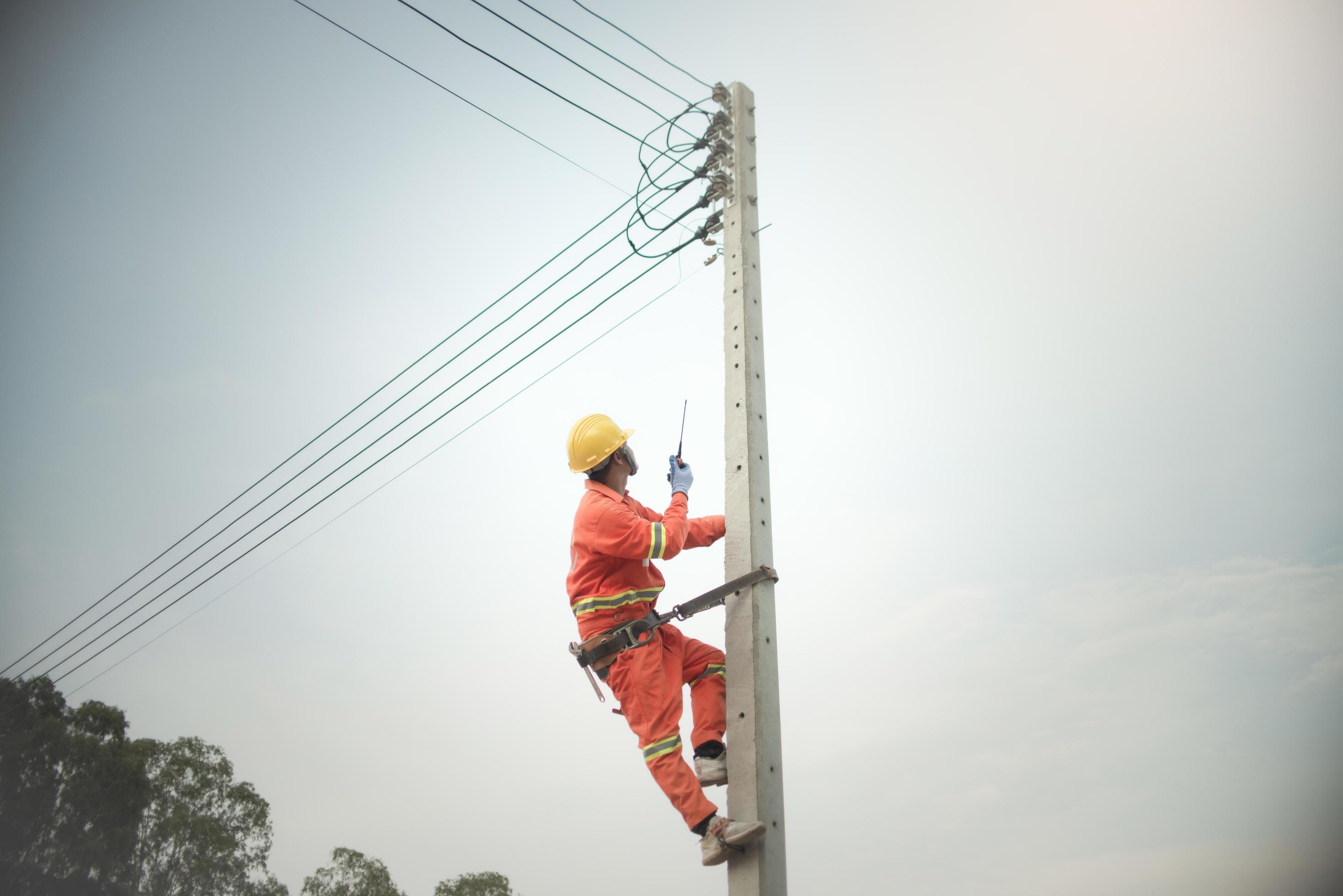 Cable lineman working from climb the lamp post on cable distribution