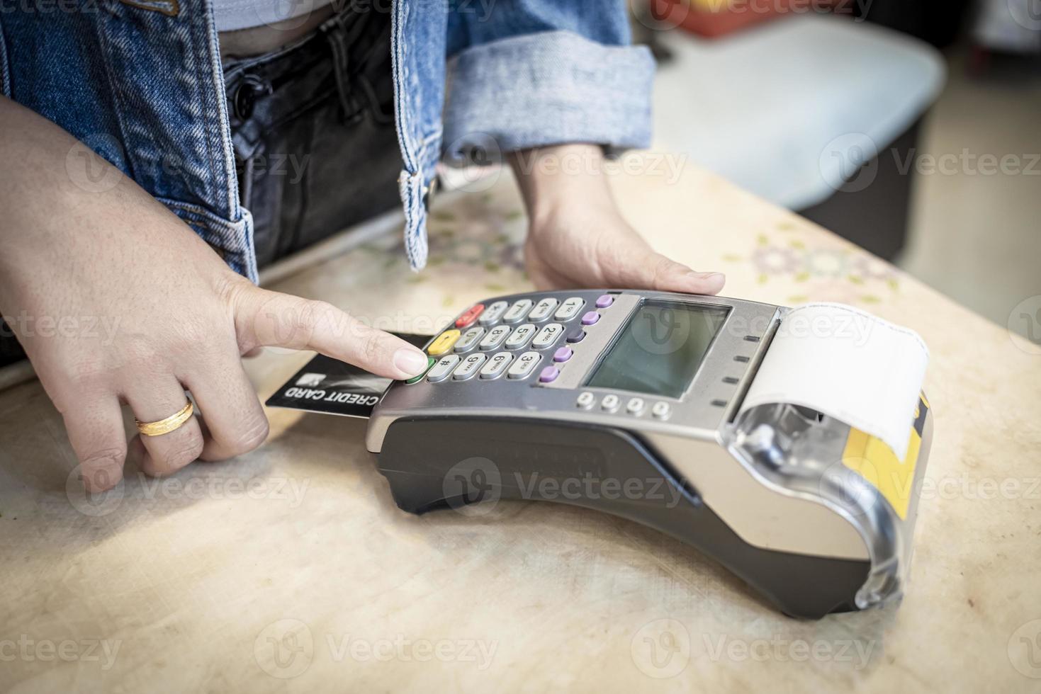 Woman hand with credit card swipe through terminal for sale in restaurant photo