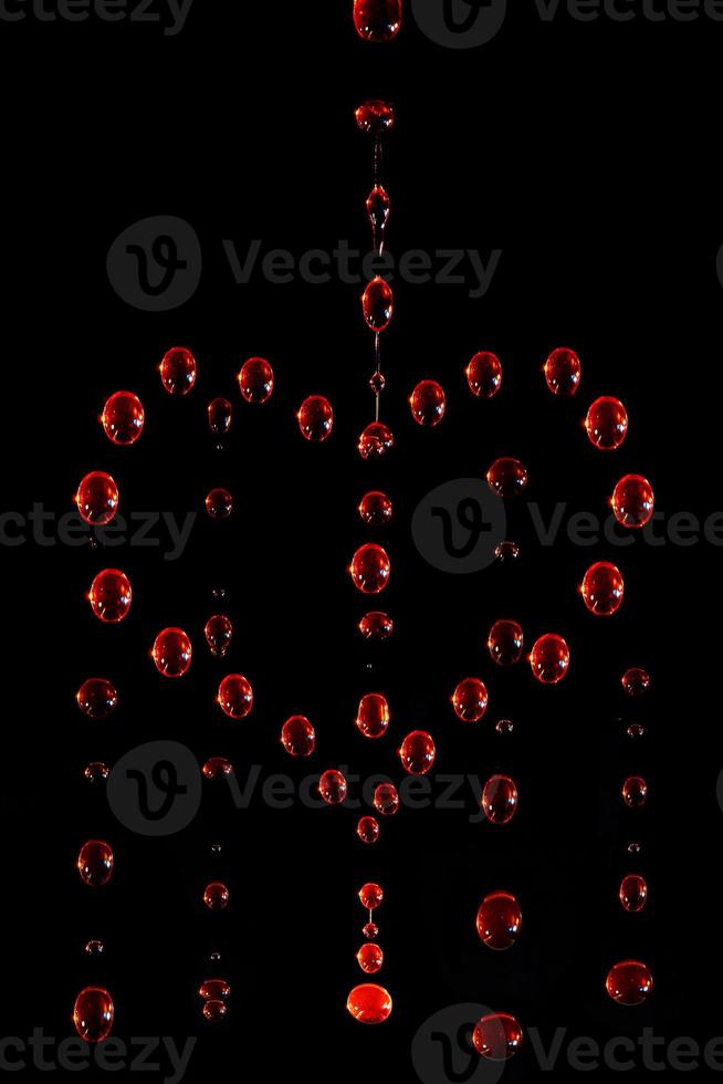 symbol of a crying heart made of red water drops on a dark background, motion blur photo