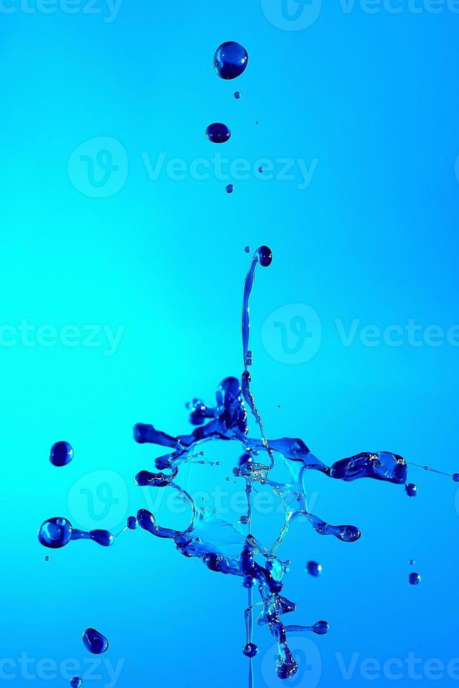 Abstract background of a splash of colored water, collision of colored drops falling towards each other. photo