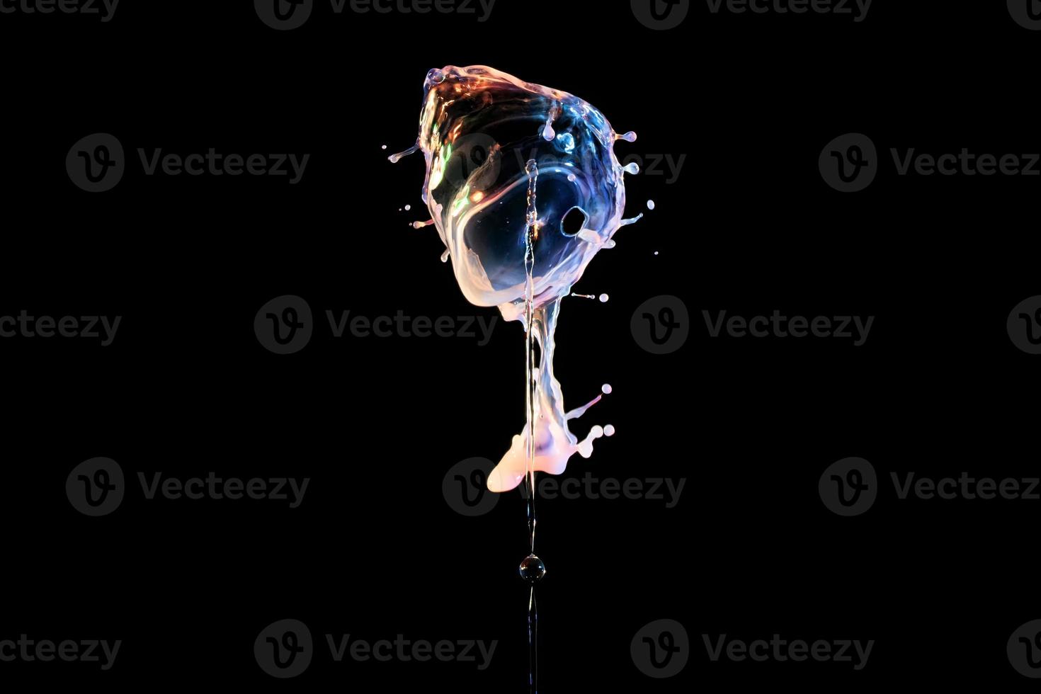 Falling drops of colored liquid, splashes on a black background, motion blur photo
