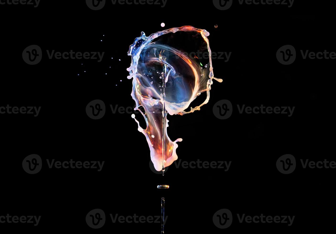 Falling drops of colored liquid, splashes on a black background, motion blur photo