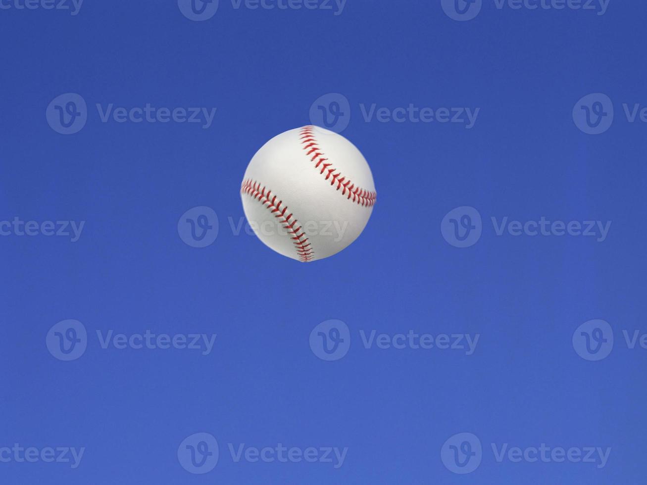 Baseball ball shot in the air with blue sky background photo