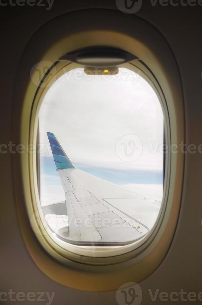 Airline window view, aircraft wing currently flying at the sky. photo