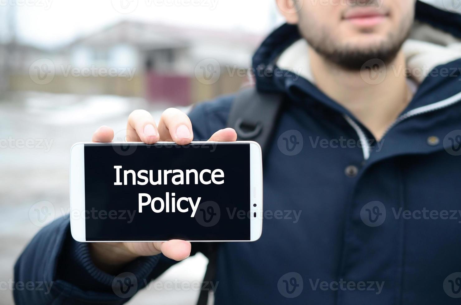 A young guy shows an inscription on the smartphone's display on photo