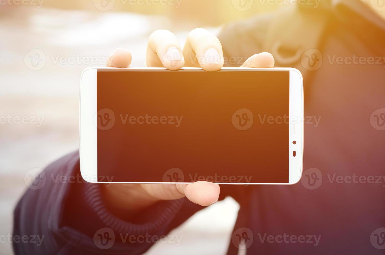 A young guy demonstrates a smartphone display on the background photo