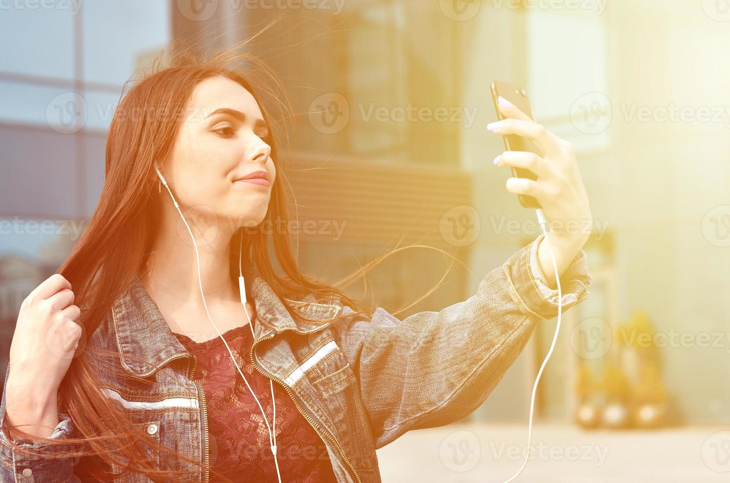 Young girl doing selfie on the background of an office building photo