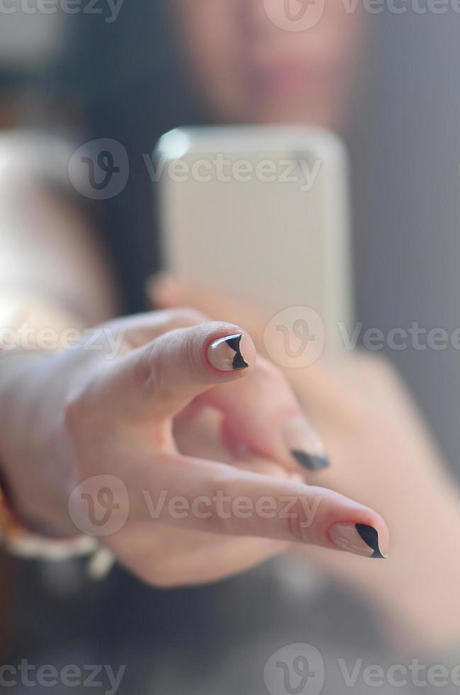 The brunette girl takes pictures of her two fingers on a modern photo