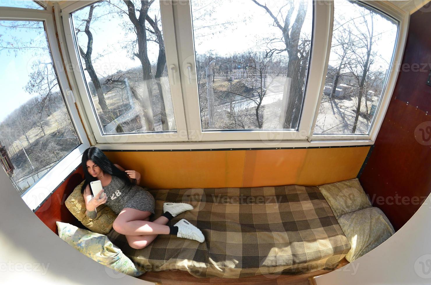 The brunette girl uses a modern touch smartphone photo