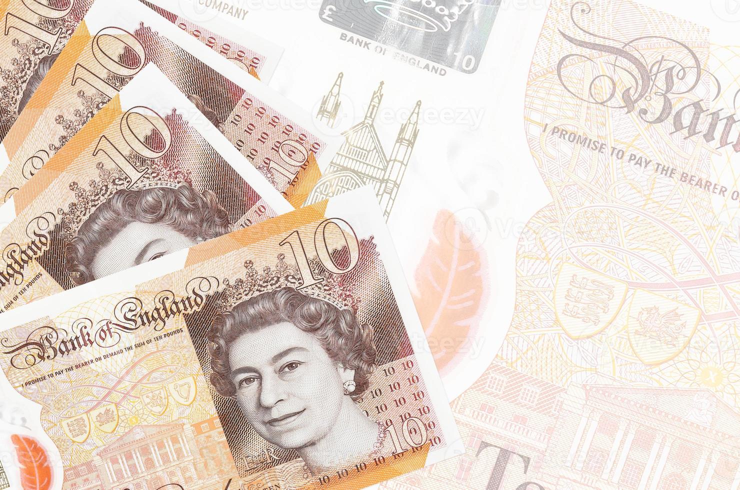 10 British pounds bills lies in stack on background of big semi-transparent banknote. Abstract business background photo