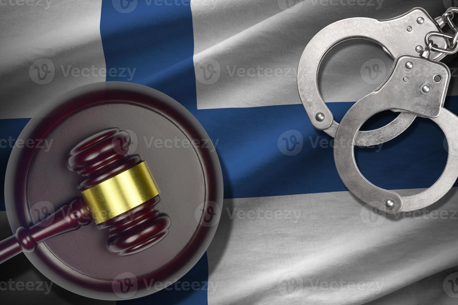 Finland flag with judge mallet and handcuffs in dark room. Concept of criminal and punishment, background for judgement topics photo