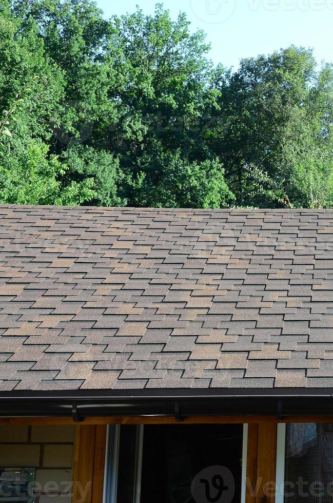 Modern roofing and decoration of chimneys. Flexible bitumen or slate shingles photo