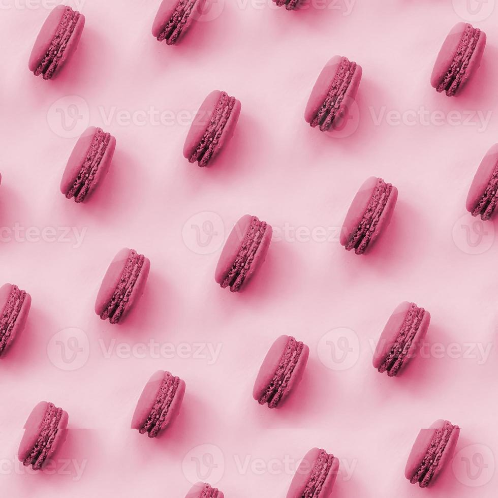Dessert cake macaron or macaroon on trendy background top view. Flat lay pattern composition Image toned in Viva Magenta, color of the 2023 year photo