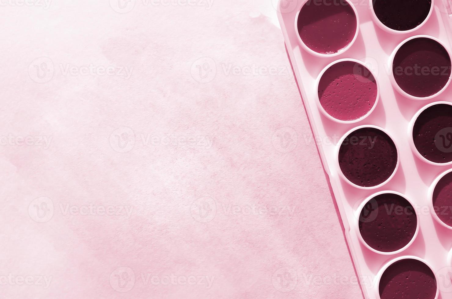 A new set of watercolors lies on a sheet of paper, which shows an abstract watercolor drawing in the form of blue strokes. Image toned in Viva Magenta, color of the year photo