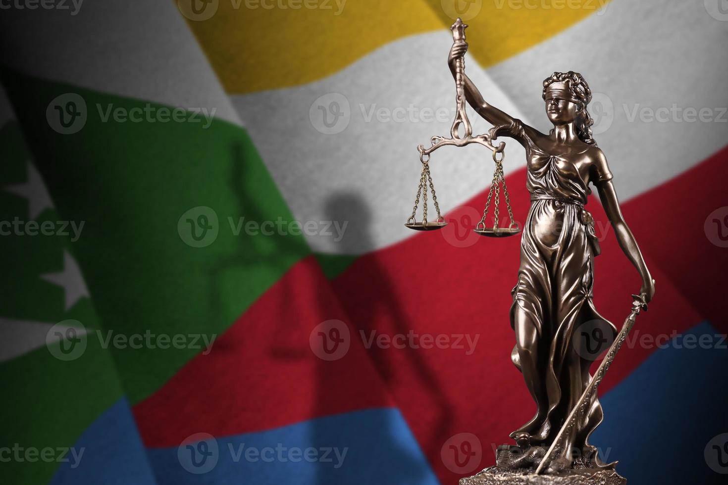 Comoros flag with statue of lady justice and judicial scales in dark room. Concept of judgement and punishment photo