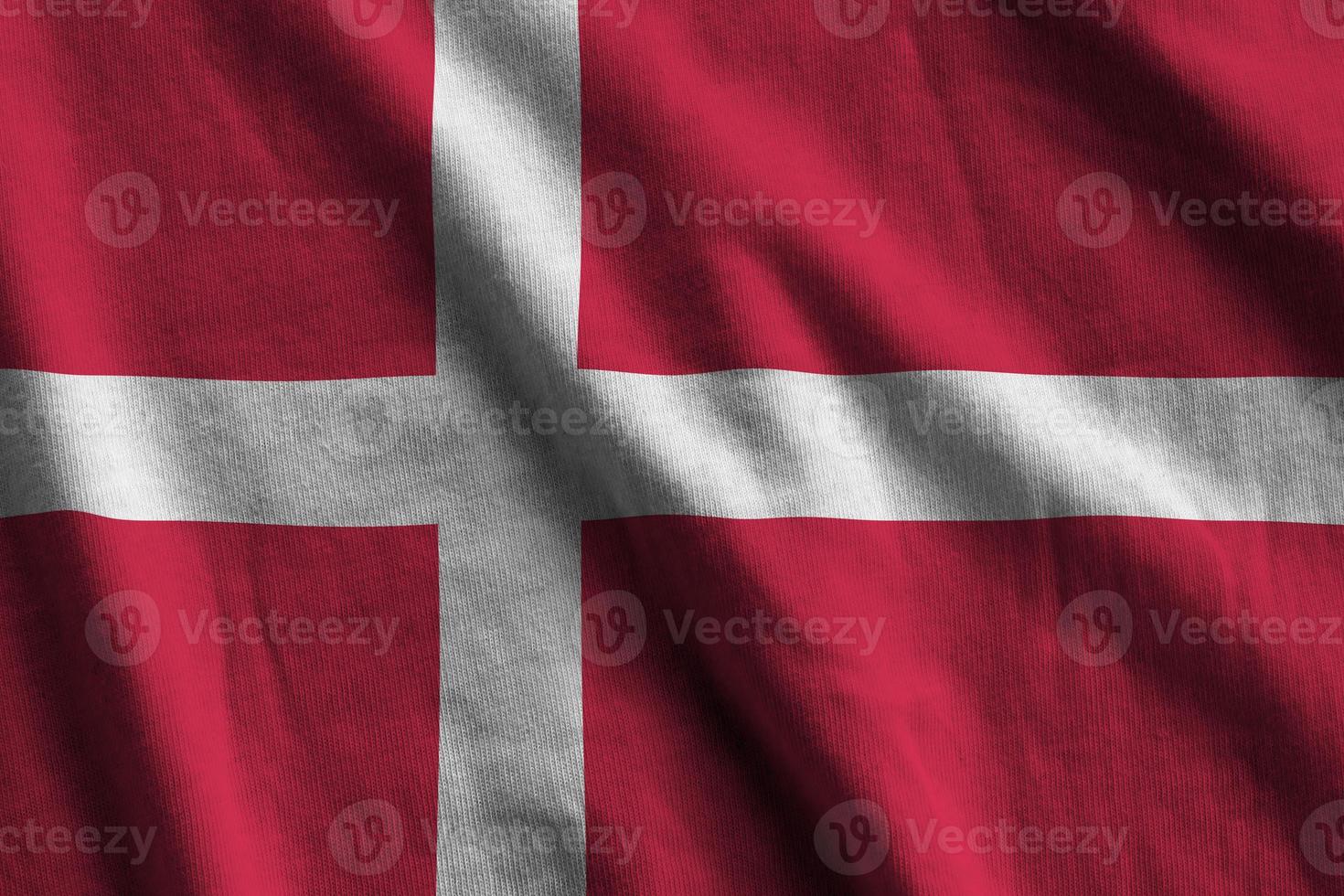 Denmark flag with big folds waving close up under the studio light indoors. The official symbols and colors in banner photo