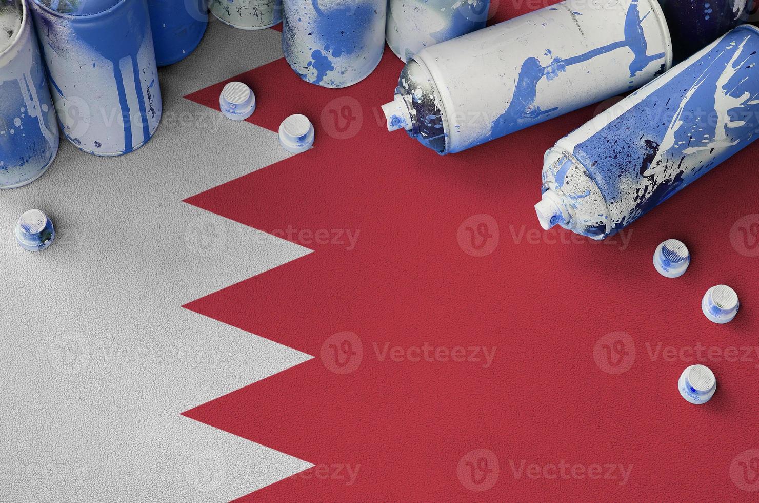 Bahrain flag and few used aerosol spray cans for graffiti painting. Street art culture concept photo