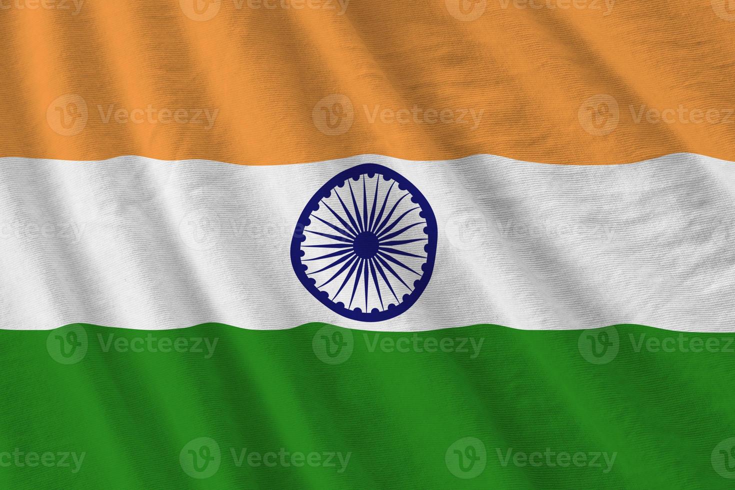 India flag with big folds waving close up under the studio light indoors. The official symbols and colors in banner photo