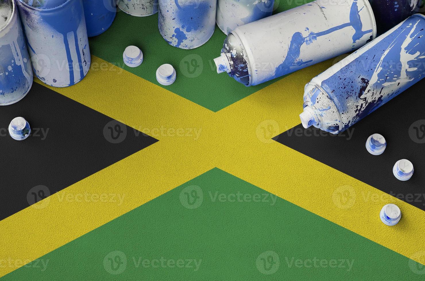 Jamaica flag and few used aerosol spray cans for graffiti painting. Street art culture concept photo