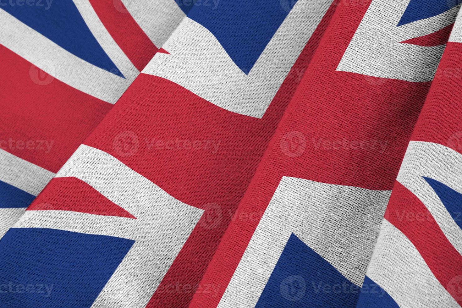 Great britain flag with big folds waving close up under the studio light indoors. The official symbols and colors in banner photo